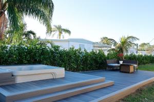 a deck with a hot tub and a table and a chair at Stylish 2BR unit w/ hot tub 5 mins from the beach! in Bonita Springs