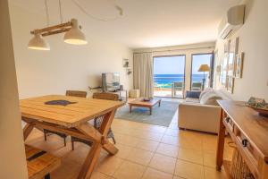 a living room with a table and a view of the ocean at Pedra do Jota in Porto Santo