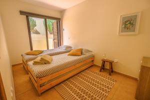 a bedroom with a bed and a large window at Pedra do Jota in Porto Santo