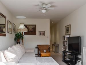 a living room with a white couch and a flat screen tv at Kingsway Apartment in Langstone