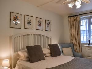 a bedroom with a bed and a chair and a window at Kingsway Apartment in Langstone