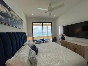 Luxury Ocean front SeaDreams 2 with 7 Mile Beach Views في West Bay: غرفة نوم مع سرير وإطلالة على المحيط