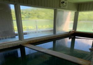 a swimming pool with three windows in a building at Fu days Condominium Jozankei / Vacation STAY 1657 in Sapporo