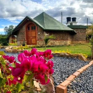 une maison avec des fleurs roses devant elle dans l'établissement Ecohotel Buenavista, à Villa de Leyva