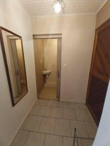 - un couloir avec une salle de bains pourvue de toilettes et d'un miroir dans l'établissement Leili Home - Papeete, à Papeete