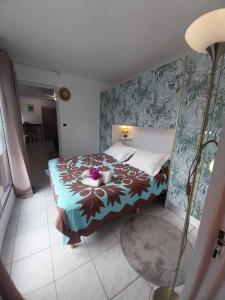 - une chambre avec un lit fleuri dans l'établissement Leili Home - Papeete, à Papeete