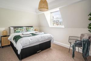 a bedroom with a bed and a window and a chair at Beautiful Character 3 Bed City Centre Apartment in Bath