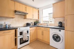 a kitchen with a washing machine and a washer at Beautiful Character 3 Bed City Centre Apartment in Bath