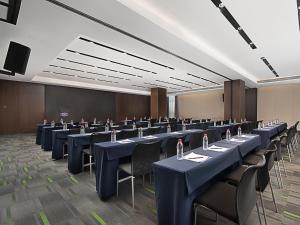 - une salle de conférence avec des tables et des chaises bleues dans l'établissement Hampton by Hilton Guangzhou Railway Station, à Canton