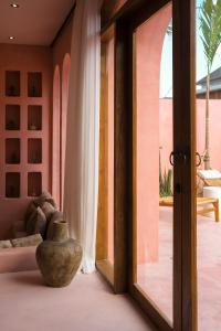 a room with a glass door with a vase next to it at Villa Ella June in Canggu