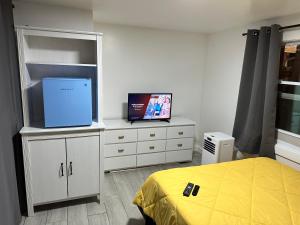 a bedroom with a bed and a flat screen tv at New Relaxing Room with Queen Bed, 50 Inch Smart TV, Netflix, AirPlay, Mini-Fridge, and 500 Mbps WiFi near FIU, Dolphin Mall, Airport in Miami
