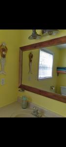 海濱公園的住宿－The Little Yellow Beach House，一间带镜子和水槽的浴室