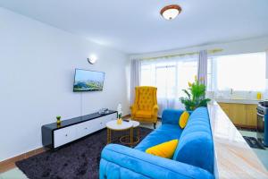 a living room with a blue couch and a yellow chair at Garden estate 1 bedroom furnished apartment in Nairobi