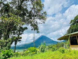 a mountain in the distance with a house and trees at Arenal Jungla Lodge in San Ramón