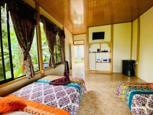 a bedroom with two beds and a large window at Arenal Jungla Lodge in San Ramón
