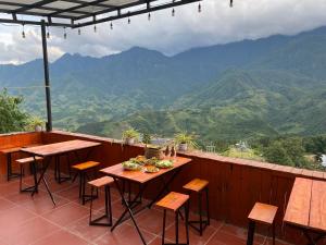 a balcony with tables and chairs and a view of mountains at D Home Sapa 3 in Sapa