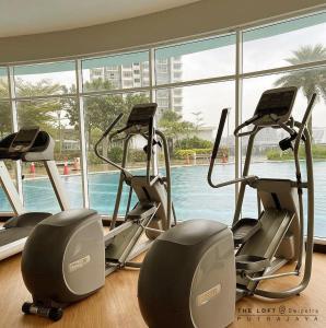 a gym with three exercise bikes in front of a large window at THE LOFT@Dwiputra Putrajaya. in Putrajaya