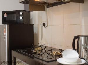 a kitchen with a stove with two pans on it at THE LOFT@Dwiputra Putrajaya. in Putrajaya