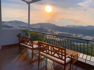 a balcony with two benches and a view of the mountains at The Sun House in Ấp Kim Thạch
