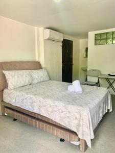 een slaapkamer met een groot bed en een witte deken bij The Victorian by Stevrena Accommodations in Ocoy