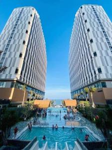 two tall buildings with a swimming pool between them at Lighthouse Apec Mũi Né in Phan Thiet