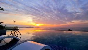 a swimming pool with a sunset in the background at Lighthouse Apec Mũi Né in Phan Thiet +7 photos