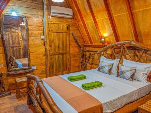 ein Schlafzimmer mit einem Bett in einer Holzhütte in der Unterkunft Sigiri Choona Lodge 'unique sunrise viewpoint' in Sigiriya