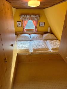 a small bed in a room with a window at Chata Sofie in Dolní Moravice