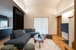 una sala de estar con un sofá y una mesa en SAKURA house Marine, en Ito