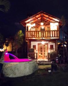 a house with a pool in front of it at night at Tiny Celina House in Baños