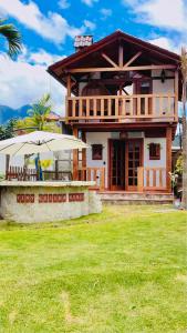 a house with two umbrellas in front of it at Tiny Celina House in Baños