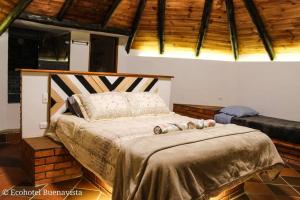 ein Schlafzimmer mit einem Bett mit zwei ausgestopften Tieren darauf in der Unterkunft Ecohotel Buenavista in Villa de Leyva