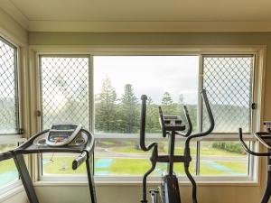 einen Fitnessraum mit zwei Heimtrainern vor dem Fenster in der Unterkunft NRMA Port Campbell Holiday Park in Port Campbell