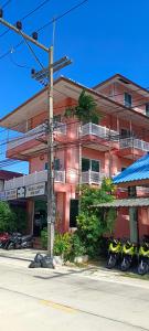 un edificio rosa con motos estacionadas frente a él en Moon Travel Phangan en Ban Nua