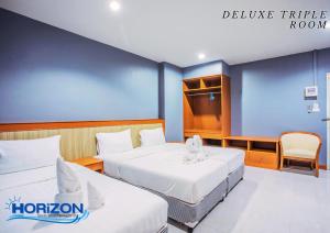 Postel nebo postele na pokoji v ubytování Horizon Hotel