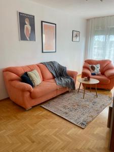 een woonkamer met een oranje bank en een tafel bij City Garden Apartment in Plovdiv