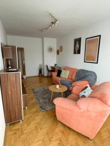 a living room with two couches and a table at City Garden Apartment in Plovdiv