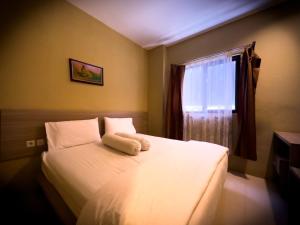 1 dormitorio con 1 cama blanca y ventana en Mess MT Haryono en Sampit
