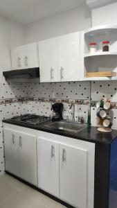 cocina con armarios blancos y fogones en 202-Cómodo y moderno apartamento de 2 habitaciones en la mejor zona céntrica de Ibagué, en Ibagué