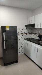 a kitchen with a black refrigerator and white cabinets at 202-Cómodo y moderno apartamento de 2 habitaciones en la mejor zona céntrica de Ibagué in Ibagué