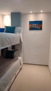 1 dormitorio con 2 literas y un cuadro en la pared en 202-Cómodo y moderno apartamento de 2 habitaciones en la mejor zona céntrica de Ibagué, en Ibagué