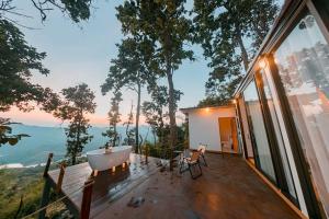 una casa con bañera en una terraza en WeddingCamp Doichang บ้านพบรัก, en Ban Sam Laem