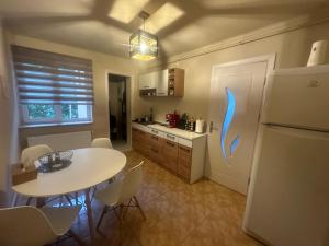 a kitchen with a white table and a white refrigerator at Apartament Maria in Băile Govora