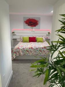 1 dormitorio con 1 cama con almohadas verdes y rojas en Modern, self-contained 2b/ 1.5 b suite w/workspace, en Distrito municipal de Maple Ridge