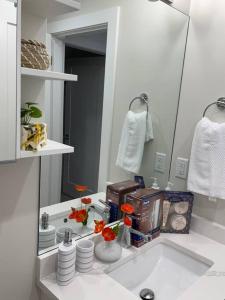 Baño blanco con lavabo y espejo en Modern, self-contained 2b/ 1.5 b suite w/workspace, en Distrito municipal de Maple Ridge