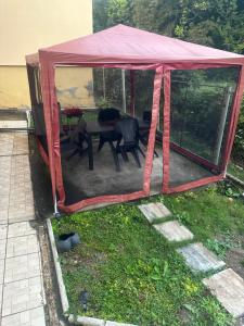 a tent with a table and chairs in a yard at Apartament Maria in Băile Govora