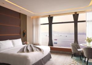 香港にあるOne-Eight-One Hotel & Serviced Residencesのベッドと大きな窓が備わるホテルルームです。