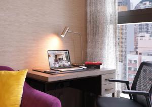 a laptop computer on a desk in a room with a window at One-Eight-One Hotel & Serviced Residences in Hong Kong