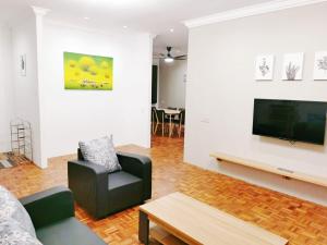 een woonkamer met een bank en een tv bij The Spring Homestay Apartment in Kuching