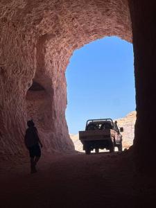 a person walking through a cave with a truck at Cozy Cave Coober Pedy in Coober Pedy